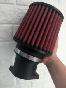 A high-performance air filter installed in a motorcycle, showcasing its fine mesh design.