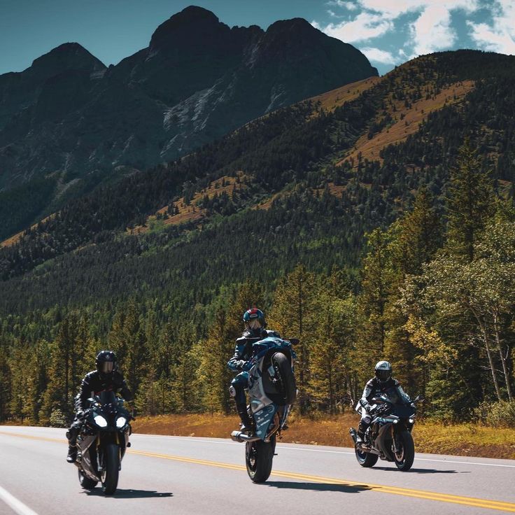 A sleek motorcycle parked on a scenic mountain road with vibrant greenery in the background.
